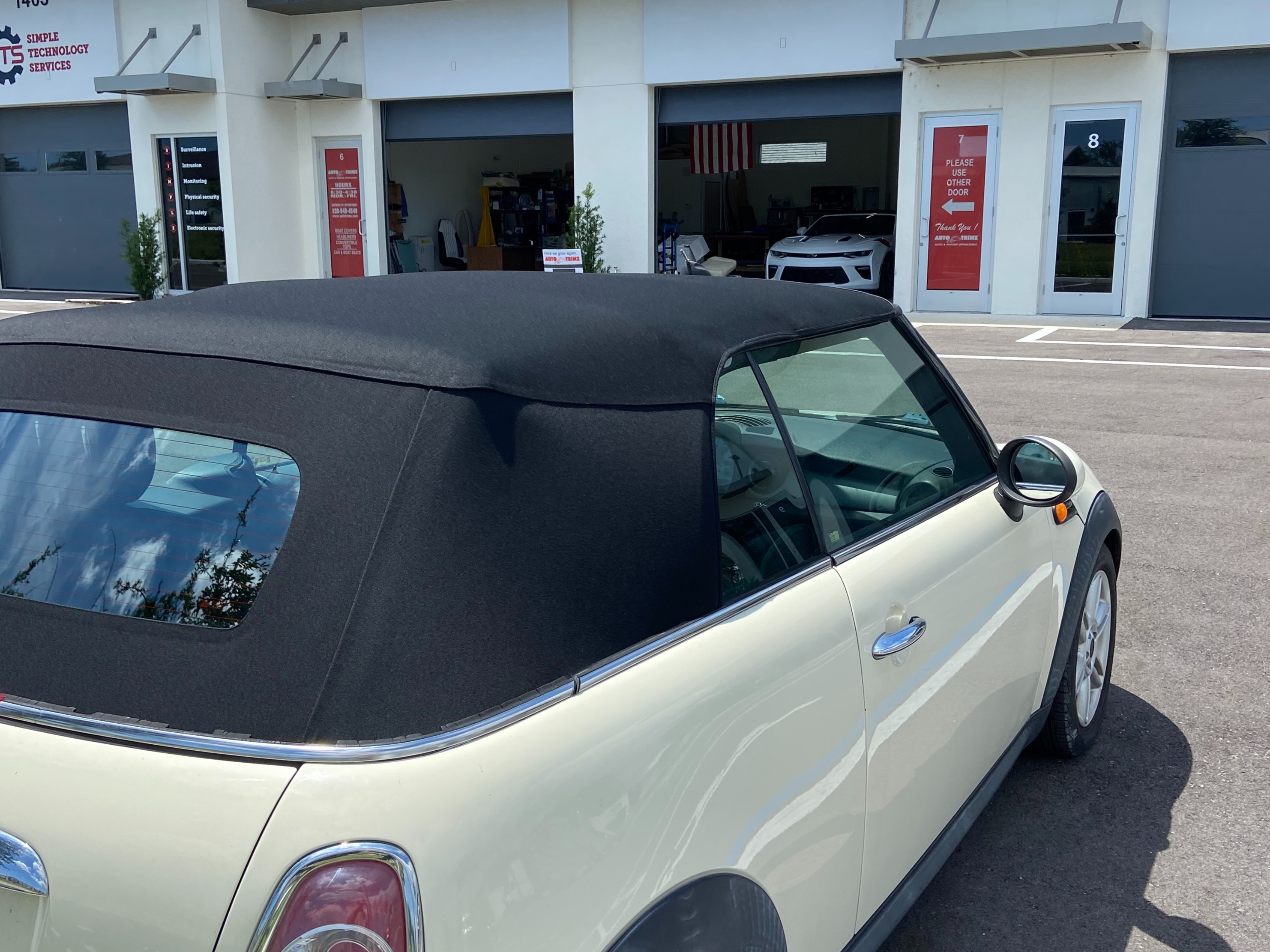 Tiny Car Parked On The Outside of The Garage